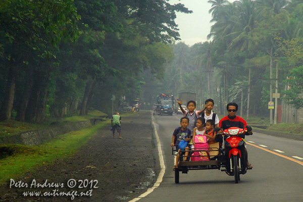 A cheeky boy off to school, along the highway to Kidapawan City, Davao del Sur Province, Mindanao, Philippines. Photo copyright Peter Andrews, Outimage Australia.