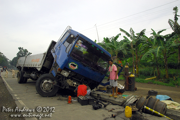 Another trucking disaster at a roadworks site along the highway to Kidapawan City, Davao del Sur Province, Mindanao, Philippines. Photo copyright Peter Andrews, Outimage Australia.