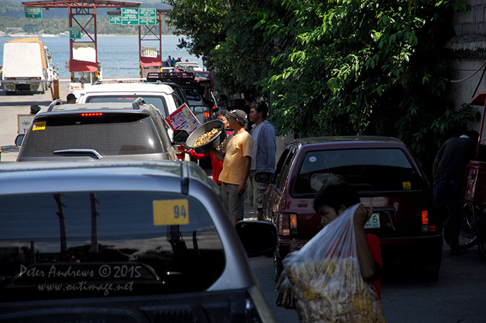 Street vendors in Davao City selling food to people waiting in vehicles for the ferry to Samal Island.