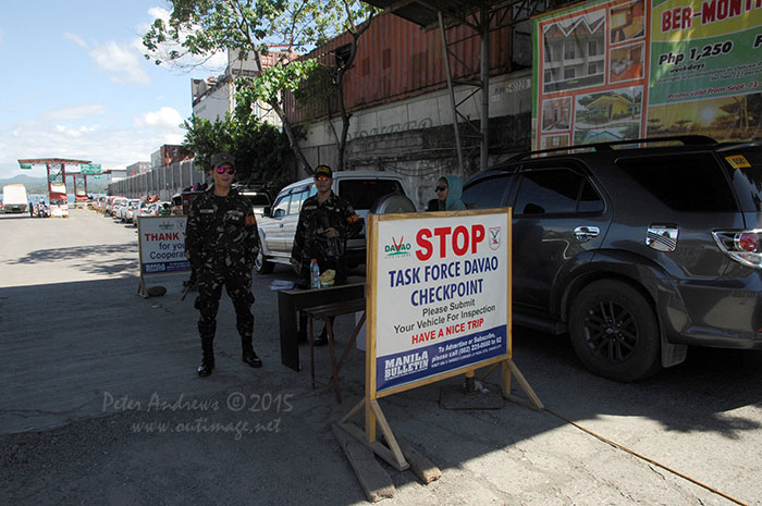 Davao City Police Task Force (who are affiliated with the Philippine Army) check returning vehicles off the ferry from Samal Island.