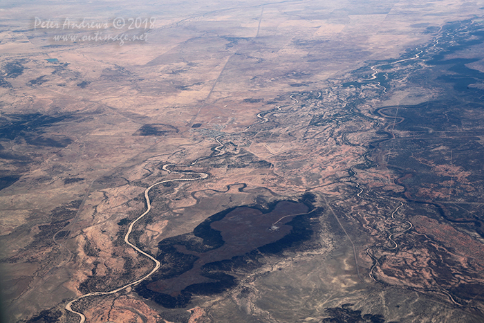 The dry Flinders River passes through the outback Queensland town of Hughenden. Left of the river is the Flinders Highway that runs between Townsville and Mount Isa and continues into the Northern Territory. On to right of the hill is the Kennedy Development Road that runs between Hughenden and the Atherton Tableland near Cairns. 20°48'59.7"S 144°19'13.4"E. High altitude shots from a flight between Sydney Australia and Manila, Philippines.