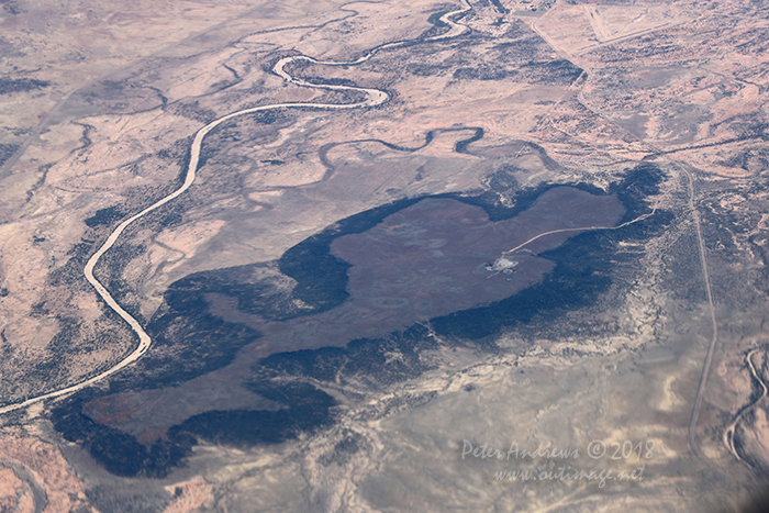 The dry Flinders River passes through outback Queensland near the town of Hughenden. Left of the river is the Flinders Highway that runs between Townsville and Mount Isa and continues into the Northern Territory. On to right of the hill is the Kennedy Development Road that runs between Hughenden and the Atherton Tableland near Cairns. 20°48'59.7"S 144°19'13.4"E. High altitude shots from a flight between Sydney Australia and Manila, Philippines.