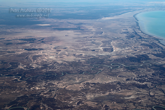 Looking across the tidal mudflats towards the Queensland outback town of Burketown with the Flinders River winding towards the Gulf of Carpentaria, near Normanton in outback Queensland. 17°48'49.5"S 140°45'39.5"E. High altitude shots from a flight between Sydney Australia and Manila, Philippines.