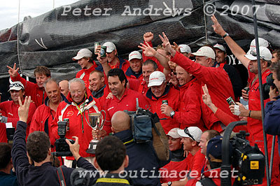 A jubilant Wild Oats crew signaling three in a row during dockside celebrations.