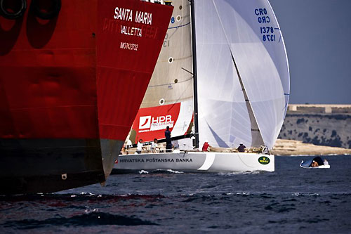 Darko Prizmic's Croatian entry AA, slips out from behind the stern of a ship during the Coastal Race, a lead up event for the Rolex Middle Sea Race 2008. Photo copyright ROLEX and Kurt Arrigo.
