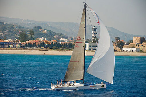 Roger Sturgeon's Rosebud / Team DYT, passing through the Strait of Messina with Capo Peloro lighthouse in the background. Photo copyright ROLEX and Kurt Arrigo.