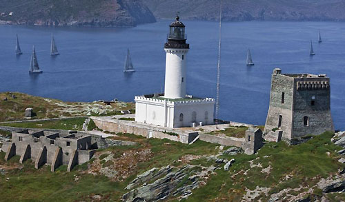 The fleet passing by the Giraglia Rock lighthouse, during the St.Tropez-Genoa, race of the Giraglia Rolex Cup 2009. Photo copyright Rolex and Carlo Borlenghi.